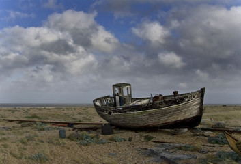 Naklejka na meble Broken down old fishing boat marooned on a beach