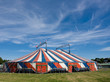 Le chapiteau bleu blanc rouge d'un cirque installé dans un champ