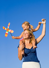 Woman and little girl playing outdoors with a propeller toy