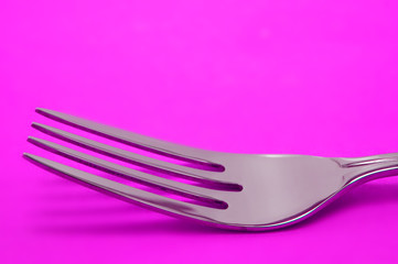 single fork on pink background