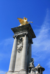 Gilded columns of Pont Alexandre II bridge in Paris France.