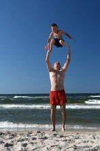 Father Throwing His Son Into The Air.