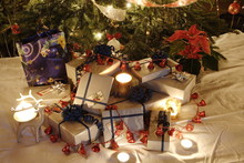 Christmas Presents And Candles Under The Tree