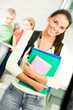 © pressmaster - Portrait of cute girl holding textbook in hands