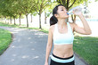 © Stephen Coburn - A young pretty asian woman drinking water after Exercise