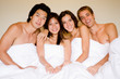 © EastWest Imaging - Four friends all sitting together in a double bed