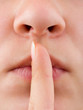 Woman holding finger to lips, gesture for silence