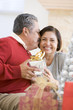 © Monkey Business - Middle Aged Couple Affectionately Sitting And Holding Christmas