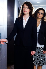 Sticker - Young businesswomen waiting for elevator at office corridor.