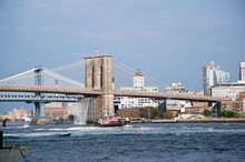 Brooklyn Bridge With Waterfalls And Tugboat