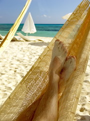 Wall Mural - Man relaxing in a hammock on a beautiful sand beach