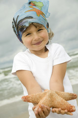 Wall Mural - Cute girl with starfish on the beach