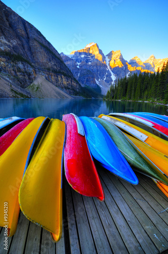 Fotografie, Obraz Canoes rest on the dock of Lake Moraine, Banff, Canada