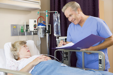 Wall Mural - Doctor Making Notes About Senior Woman Patient