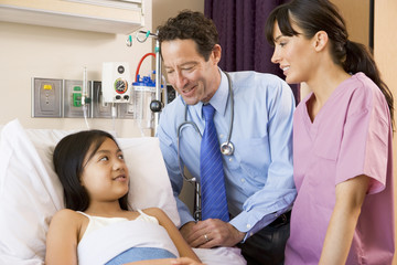 Wall Mural - Doctor And Nurse Talking To Young Girl