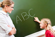 © pressmaster - Image of smart girl pointing at letter on blackboard