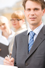 Canvas Print - Portrait of male professional on background of businesswomen