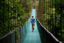 Young Man Running Over A Jungle Bridge