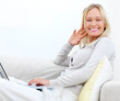 Woman sitting on sofa and using laptop