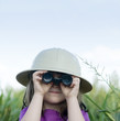 © BCFC - Young child looking through toy binoculars wearing safari hat