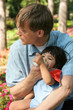© Jaren Wicklund - Father feeding baby a bottle in the park