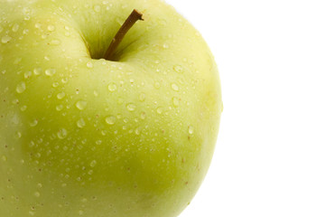 Green delicious apple with drops of water on a white background