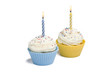 Two cupcakes with candle on white background