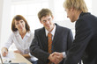 © chagin - Photo of businessmen  handshaking with woman near by