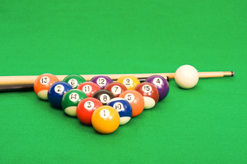 billiard balls arranged on a green material covered pool table