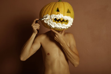 Wall Mural - Surrealistic portrait of young man with pumpkin on head