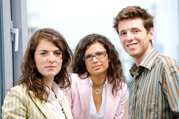 Poster - Happy young businesspeople talking in front of office window,