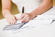 © AVAVA - Woman writing checks from checkbook to pay monthly bills