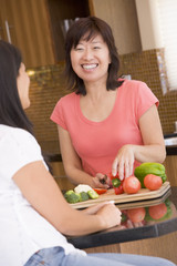 Wall Mural - Woman Chatting To Friend While Preparing meal,mealtime