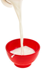 streem cool milk pouring in redden cup on white background