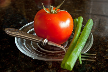 Wall Mural - Fresh tomato and green onions on the pretty glass plate.