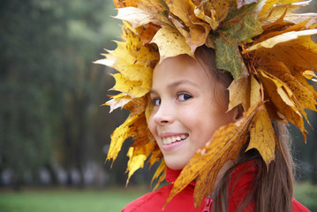 Cheerful preteen girl in yellow leaf garland