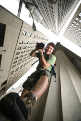 Fototapete - Photographer in New York City. Wide angle view from below.