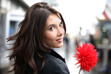 Beautiful Woman With Red Flower Looking Back. Shallow DOF.