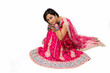 Beautiful Bangali bride in colorful dress sitting, isolated