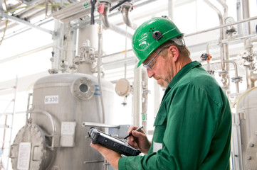 Middle aged industrial worker with notebook