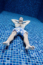 An Underwater Shot Of A Man In A Swimming Pool Trying To Relax