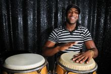 Portrait Of Young Latino Percusionist Playing African Drums