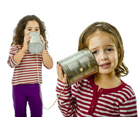 two girls talking on a tin phone isolated on white