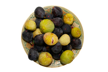 Wall Mural - Stack of black and yellow figs on the plate isolated on white.