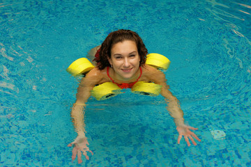 Wall Mural - The girl is engaged aqua aerobics with dumbbells