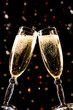 Two champagne glasses making toast over holiday background