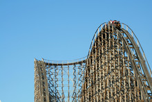 Wooden Roller Coaster Support Beams Against Blue Sky