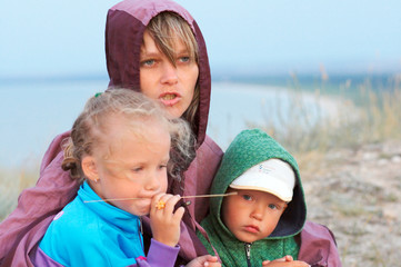 Wall Mural - mother with small girl and boy on evening prairie near sea coast