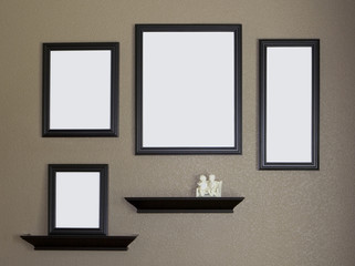 Four black blank picture frames against a brown wall