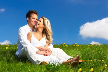 Wall Mural - young love couple smiling under blue sky.